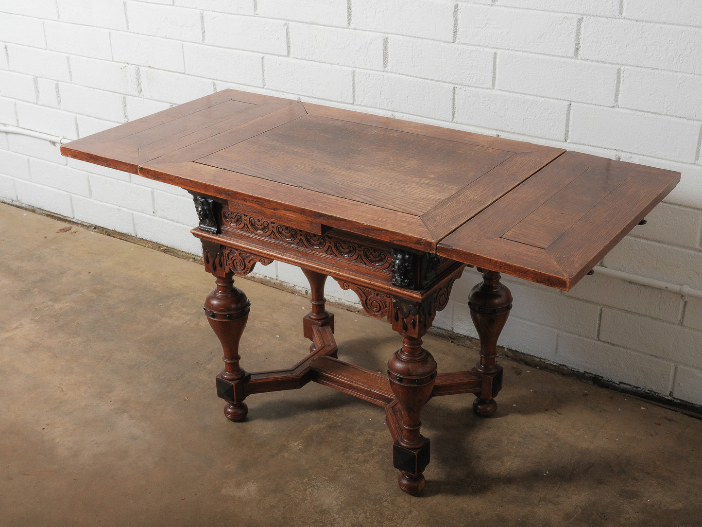 Antique Renaissance Revival Extendable Oak Table with Carved Masks and Ornate Detailing