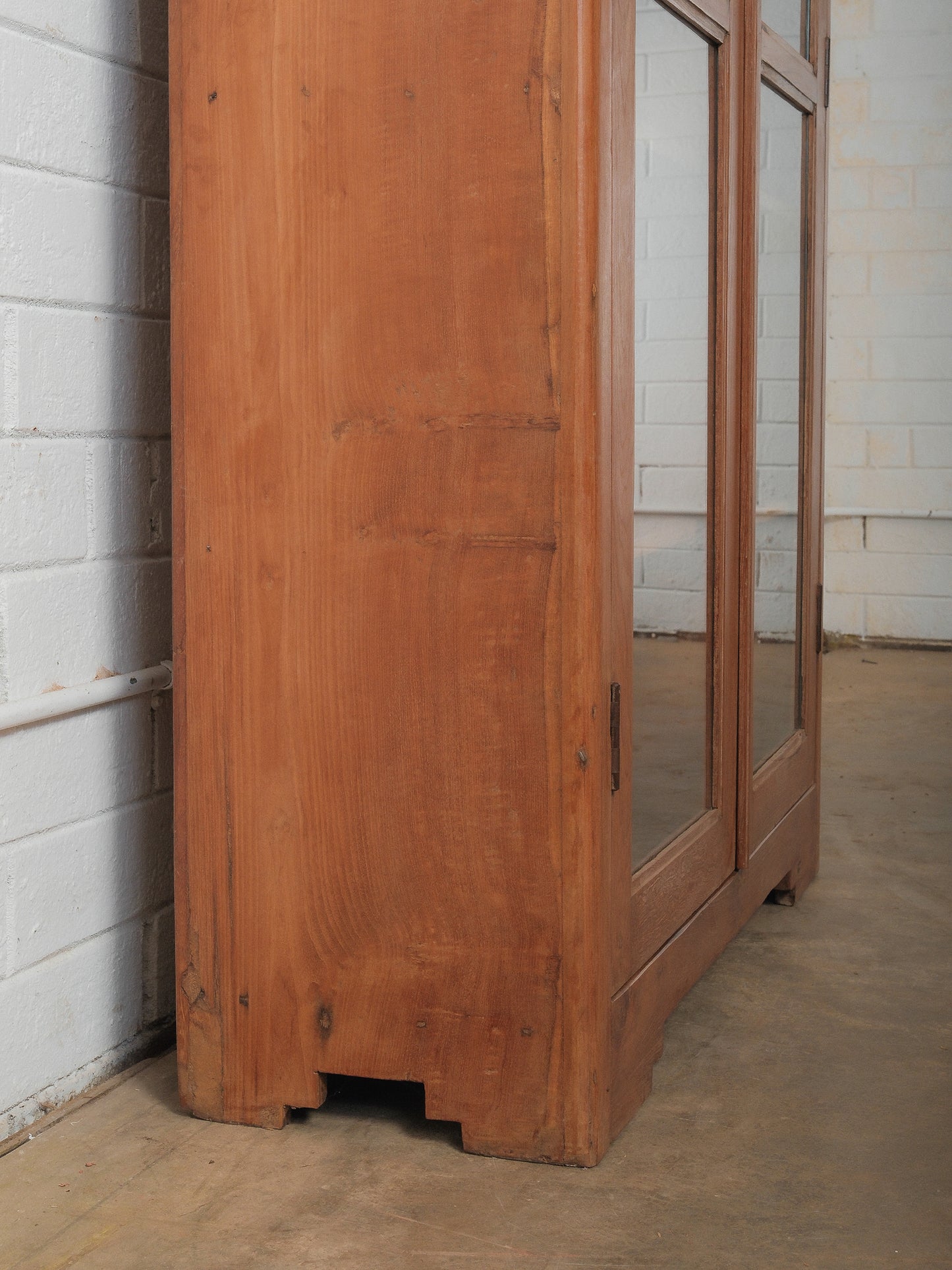 Tall Wooden Glass-Front Display Cabinet with Paneled Sides and Brass Hardware